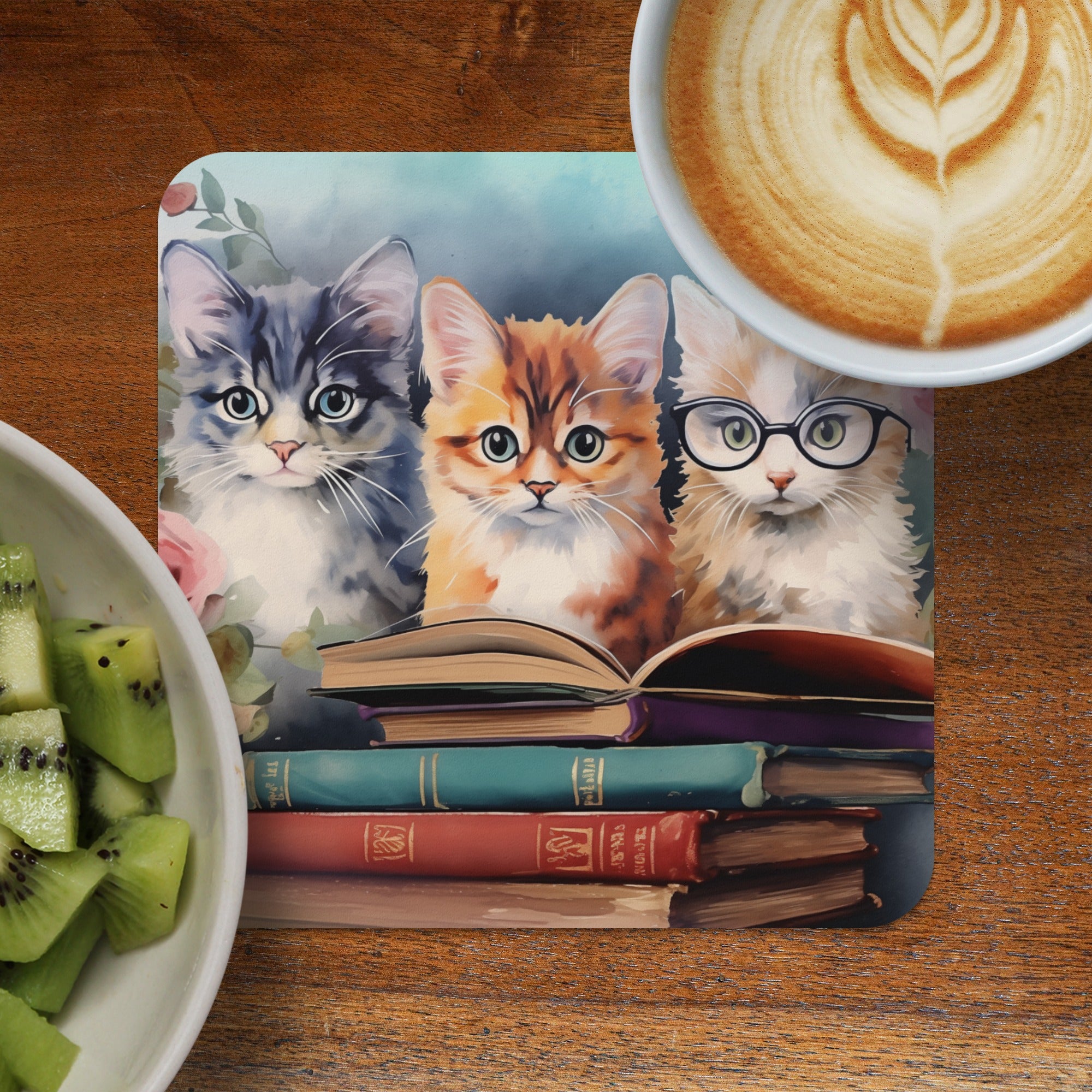 Three kittens with books and a coffee cup with latte art.
