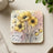 Yellow poppies with "live a great story" quote on square coaster.