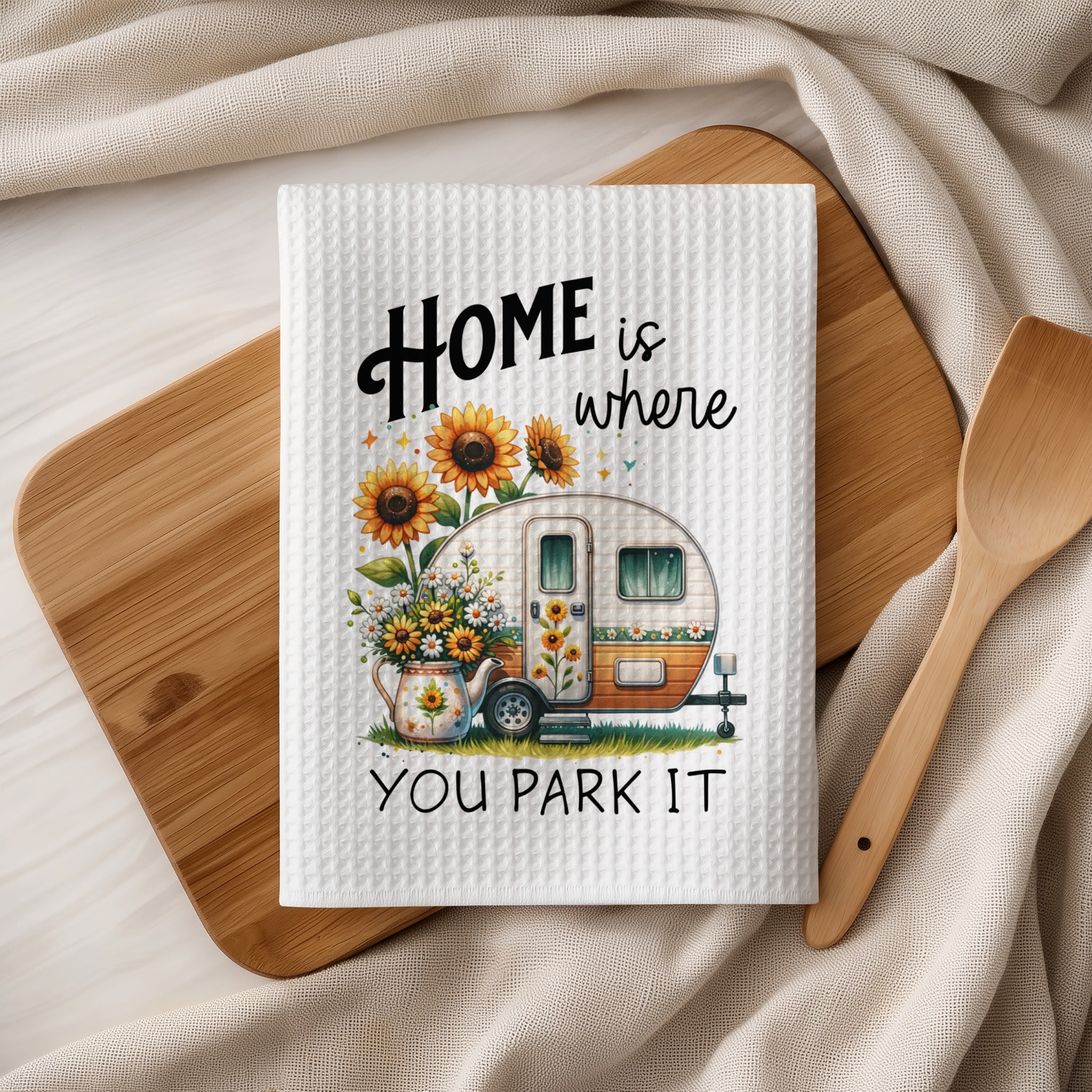 White waffle weave towel with "HOME is where YOU PARK IT" text and a camper with sunflowers.