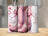Pink cowboy boots with flowers and stars on tumblers.