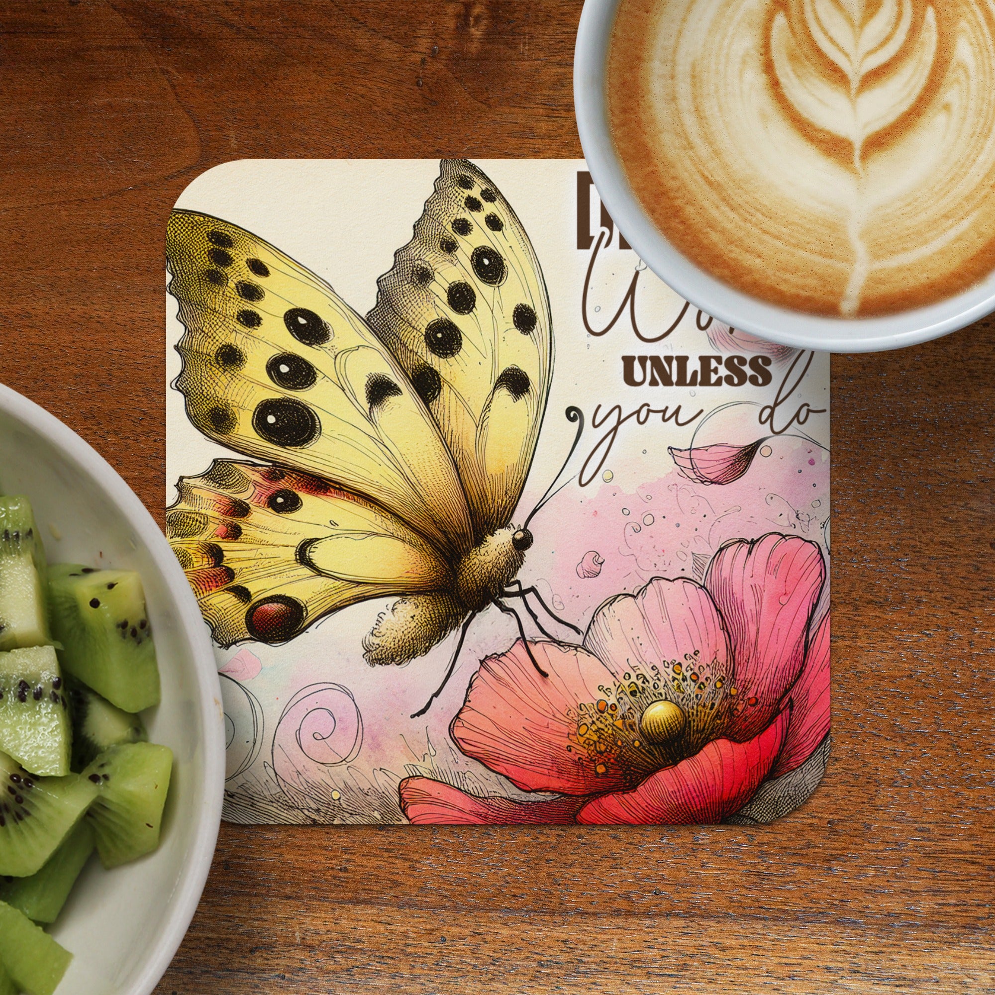 Butterly and poppy design on coaster with coffee and kiwi slices.