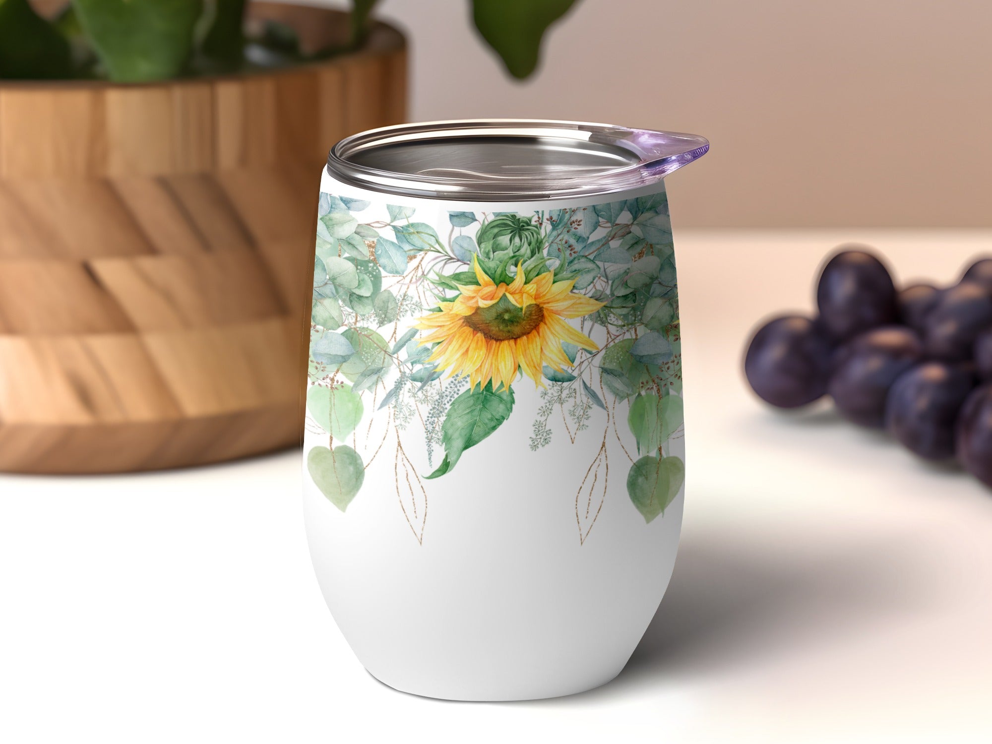 White tumbler with sunflower and eucalyptus leaf design.