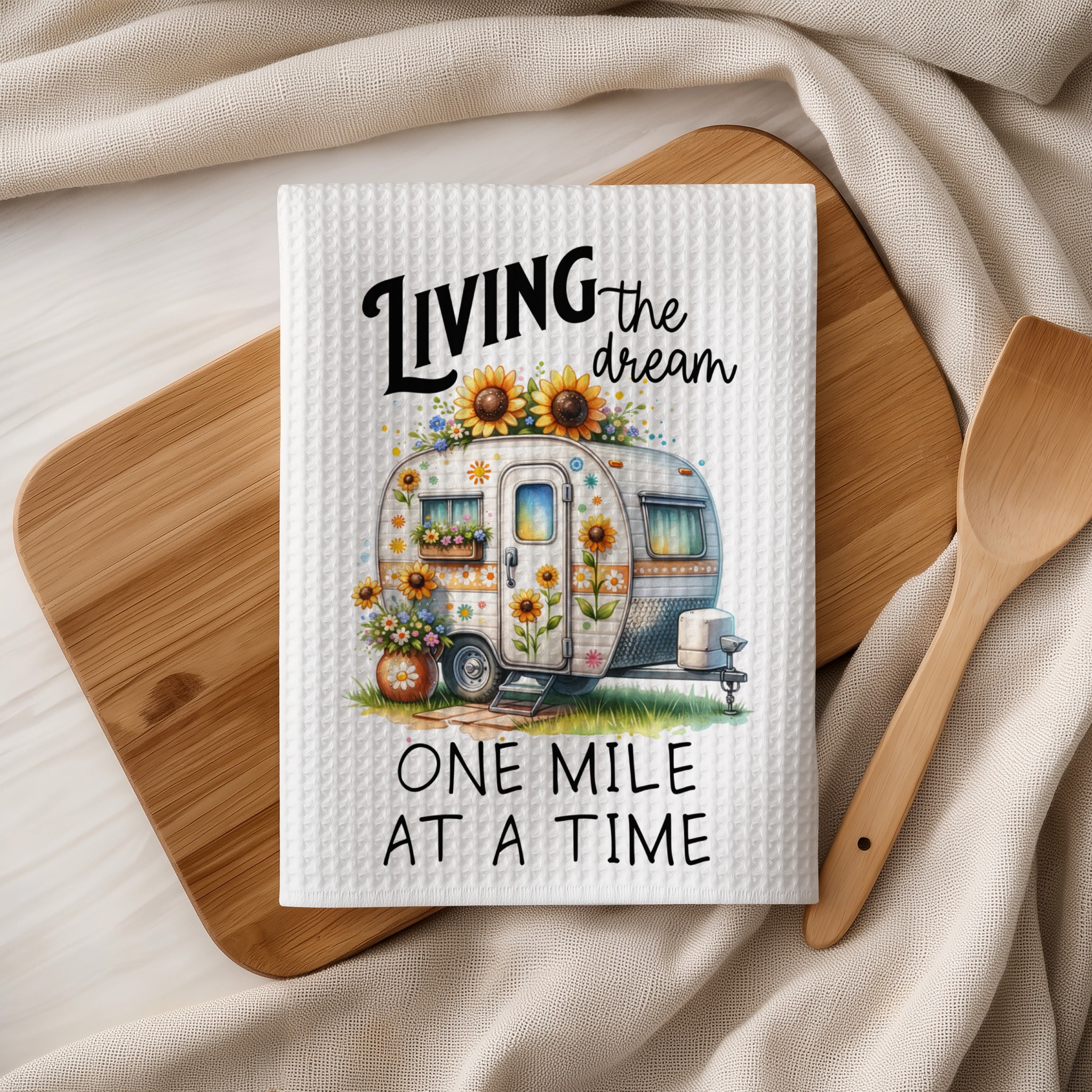 Waffle weave kitchen towel with vintage camper and text "Living the dream, One mile at a time".