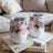 Two floral patterned wine tumblers with silver lids sit on books.
