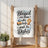 "Blessed are those who help wash the dishes" kitchen towel on a wooden rack.