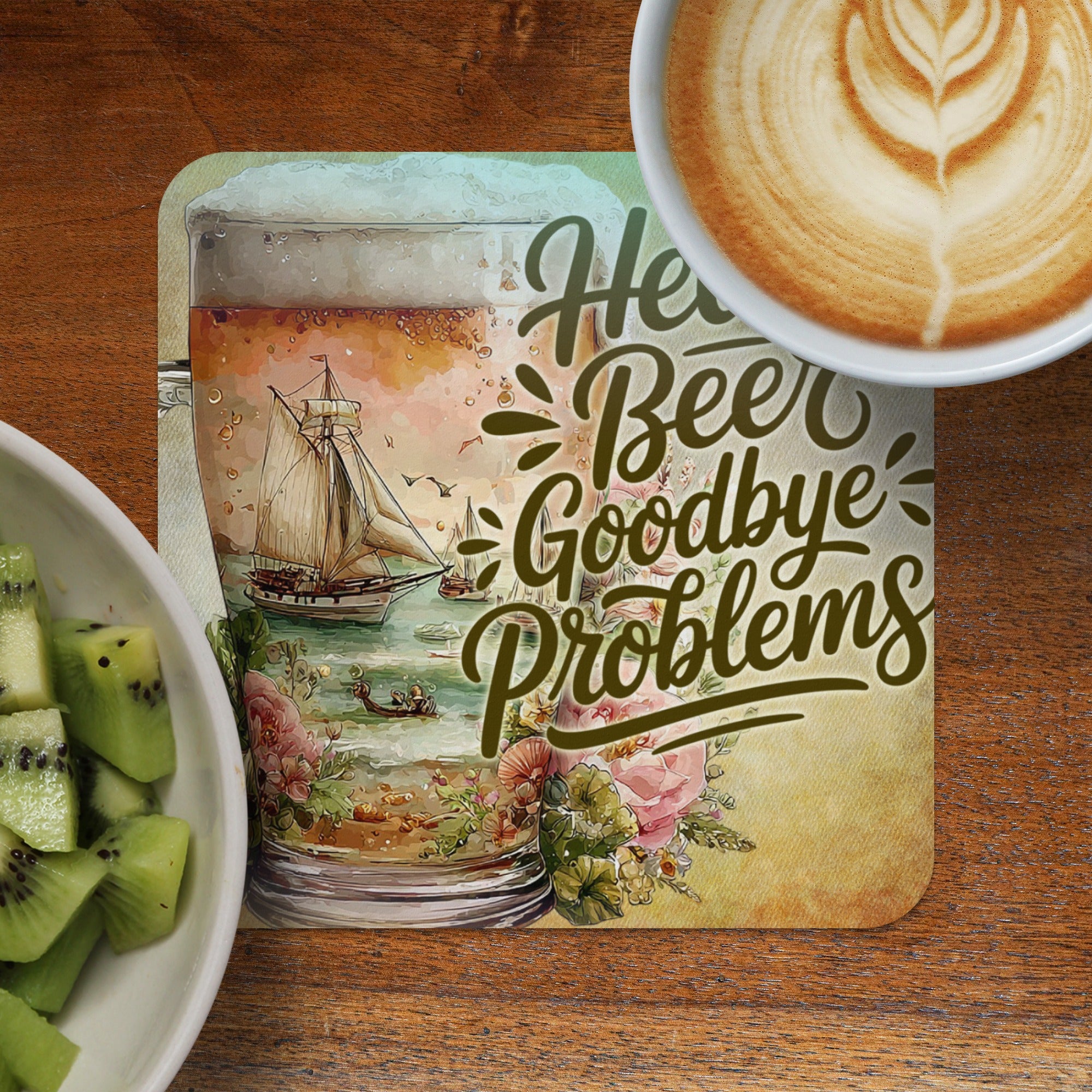Coaster with "Hello Beer Goodbye Problems" text and sailing scene with coffee and kiwi.