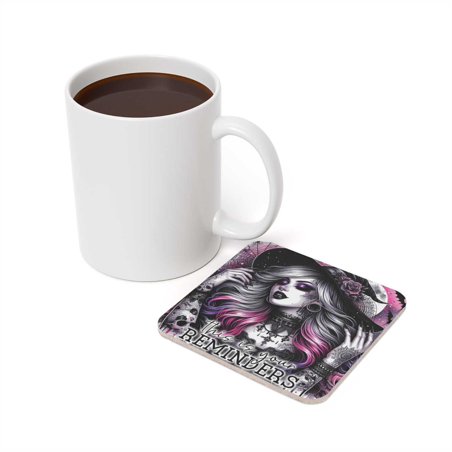 White mug beside a coaster with a witchy woman and skulls illustration.