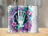 Floral and butterfly design with skeleton hand on a tumbler.