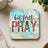 Square coaster with "but first PRAY" in distressed wood and animal print letters.