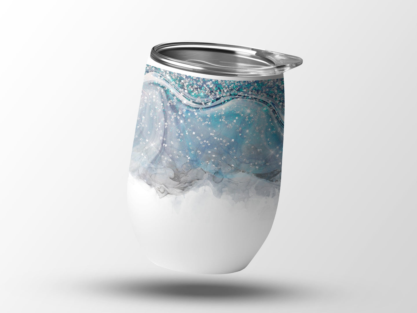 White tumbler with blue and silver glitter wave pattern.