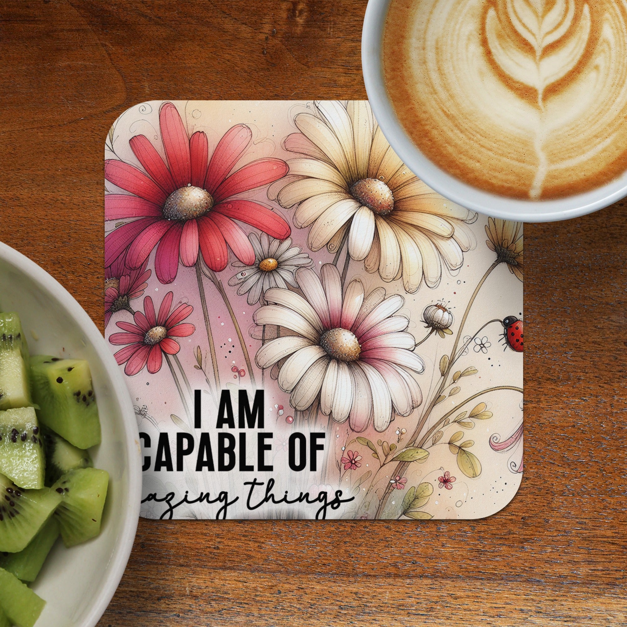 Coaster with flowers and text "I AM CAPABLE OF amazing things", with kiwi and coffee.