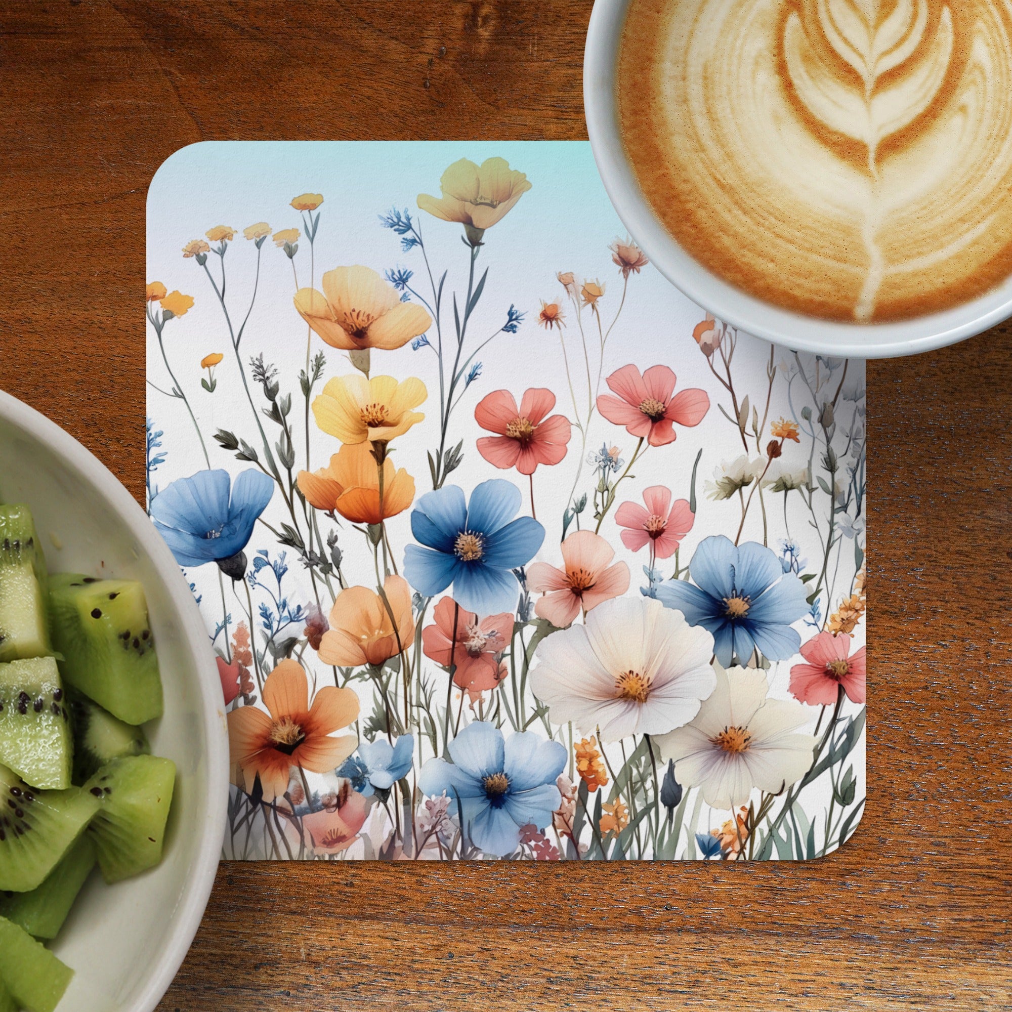 Floral placemat with coffee and kiwi fruit on wooden table.