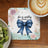Coaster with blue bow, "she is worthy PROVERBS 31", and floral design.
