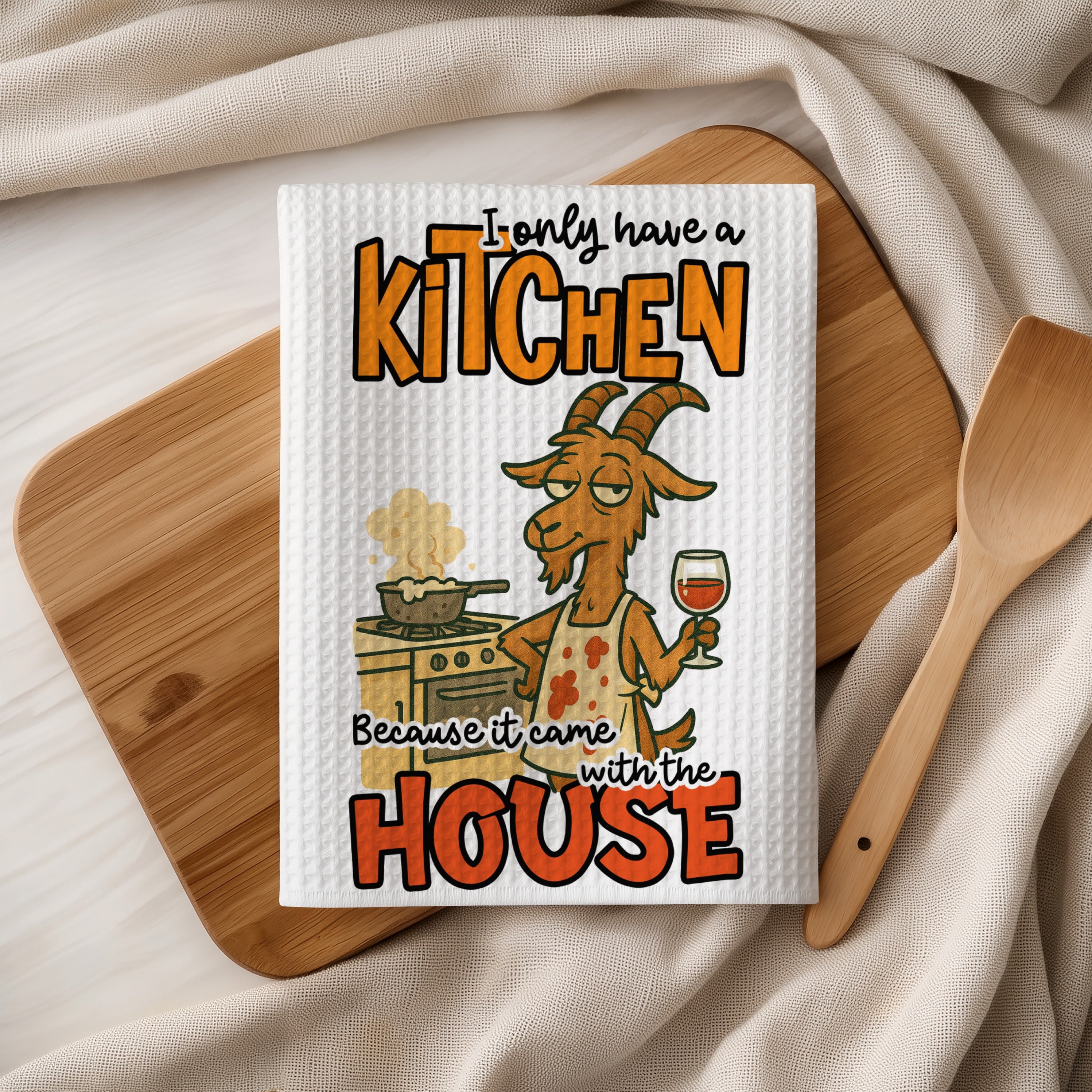 Tea towel with goat in apron cooking, "I only have a kitchen because it came with the house."
