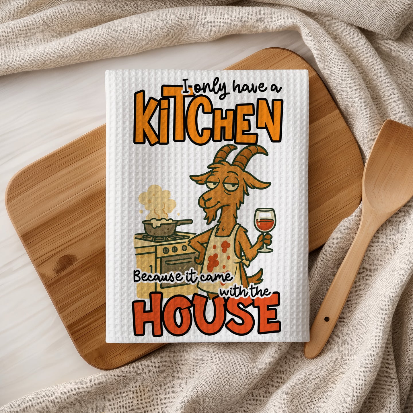 Tea towel with goat in apron cooking, "I only have a kitchen because it came with the house."
