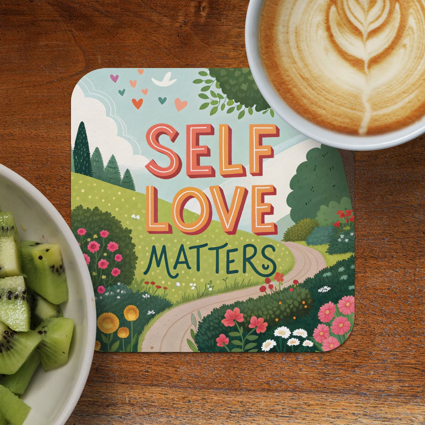 Coaster with "Self Love Matters" text, cheerful landscape, and cup of coffee.
