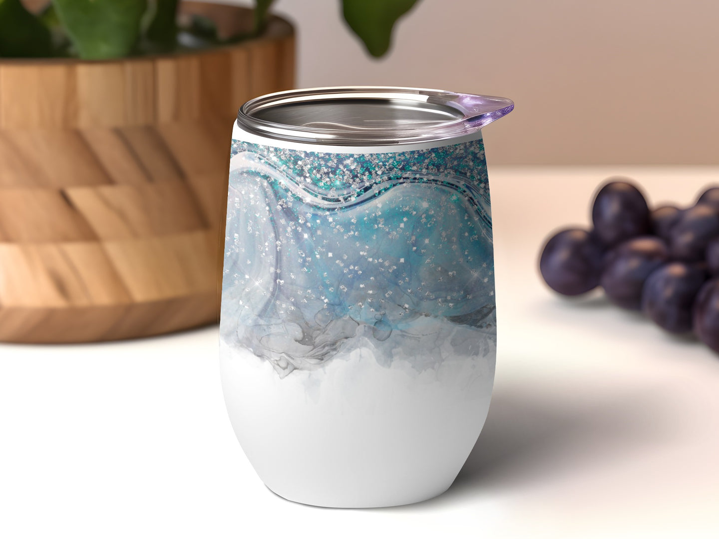 White tumbler with abstract blue and silver glitter design.