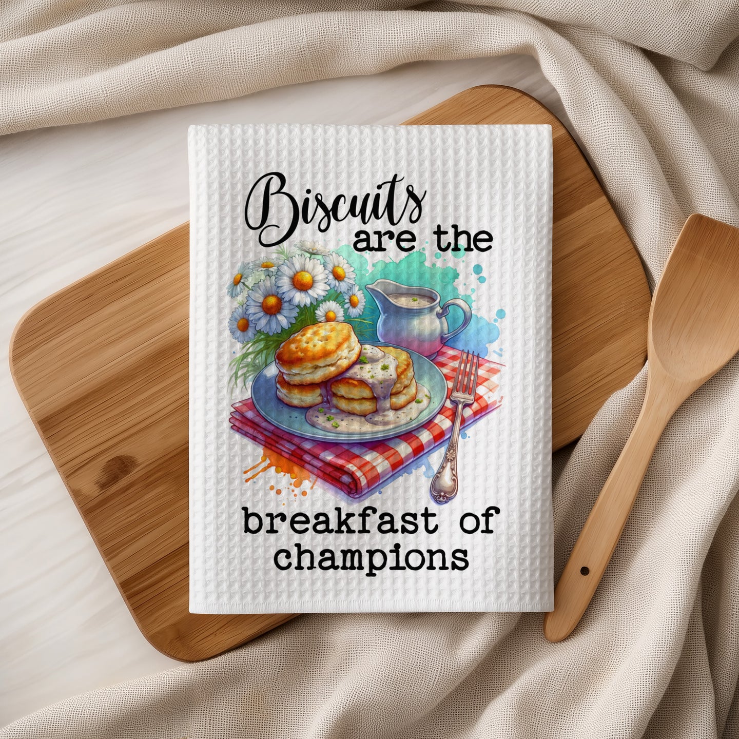 White waffle weave kitchen towel with "Biscuits are the breakfast of champions" text and biscuit illustration.