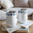 Two white tumblers with blue floral trim, resting on books.
