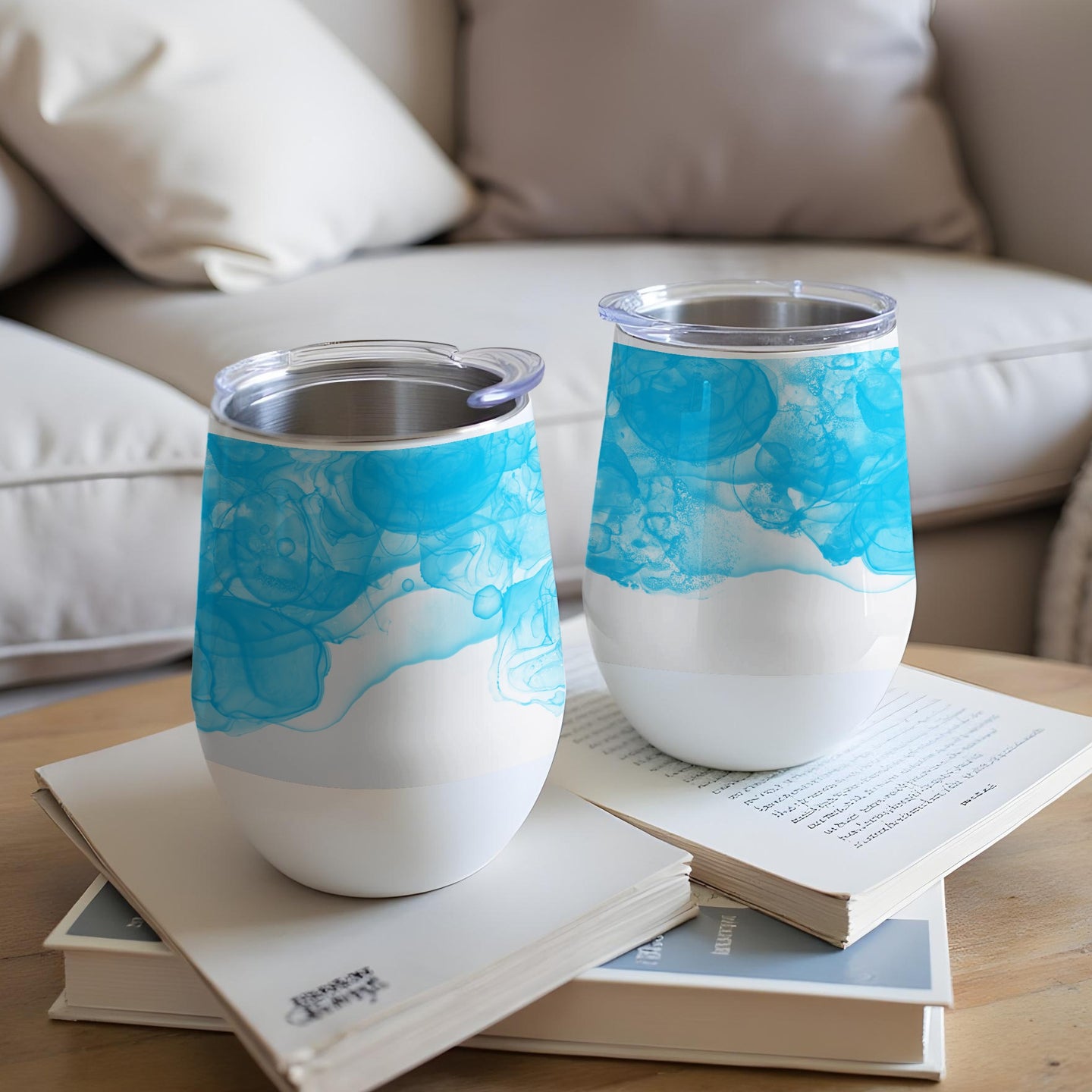 Two white stemless wine tumblers with blue watercolor patterns.