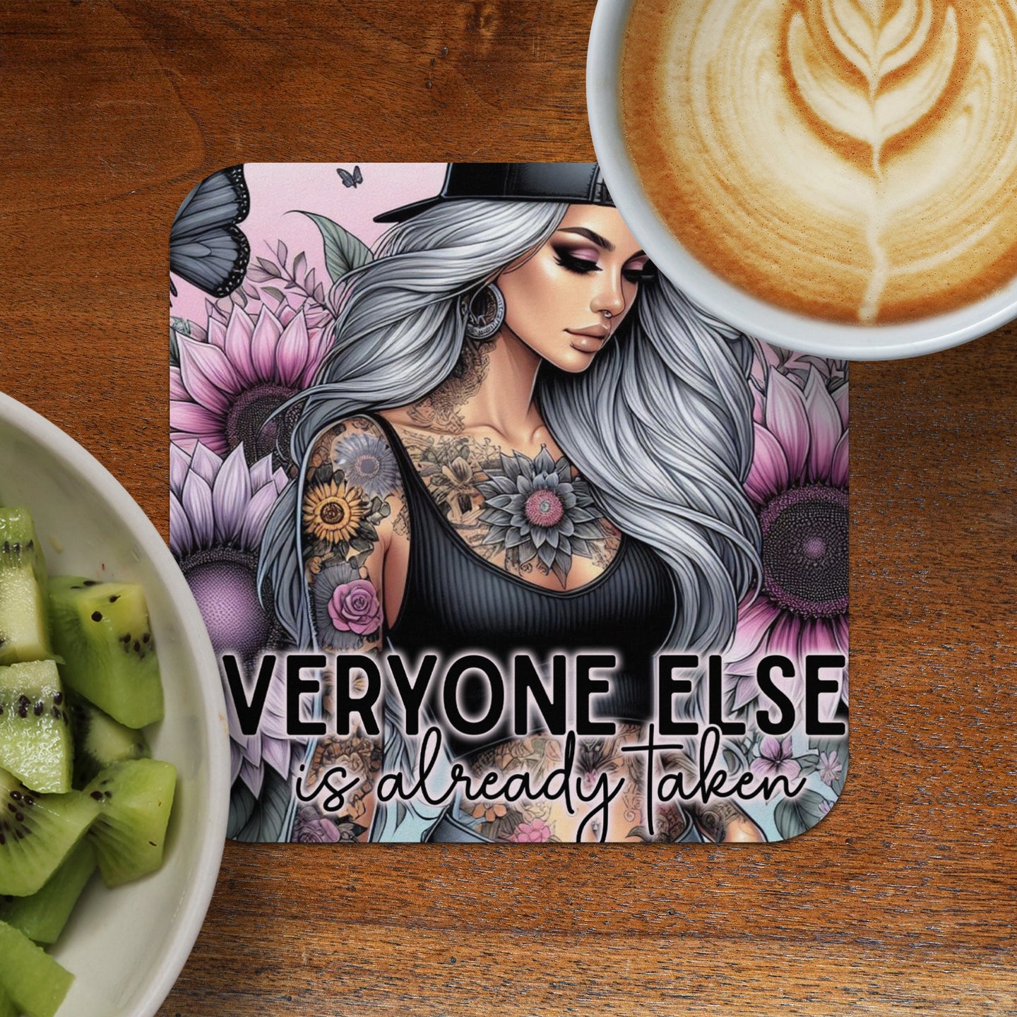 Woman with tattoos and flowers on a coaster, with text "everyone else is already taken".