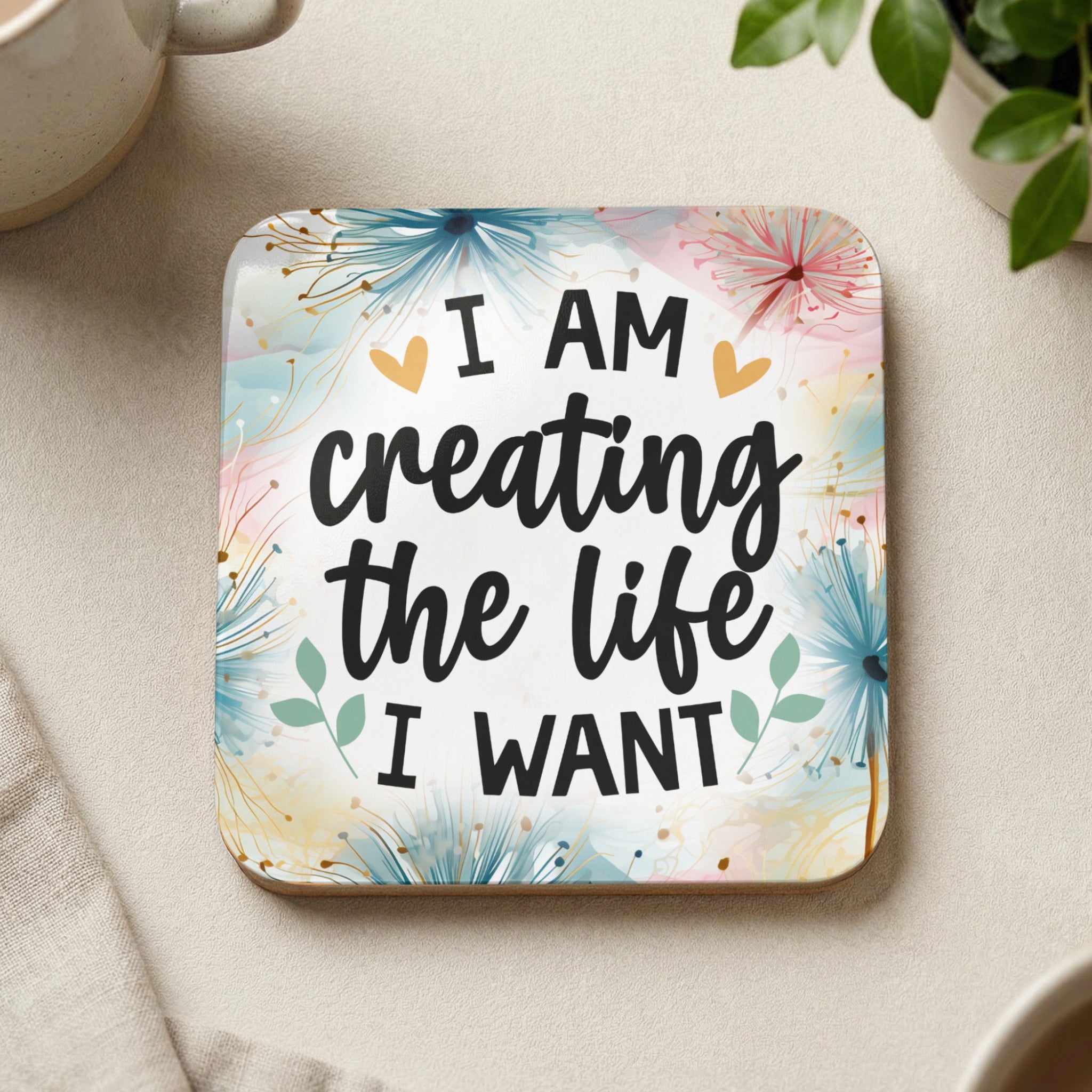 Square coaster with "I AM creating the life I WANT" text and floral design.
