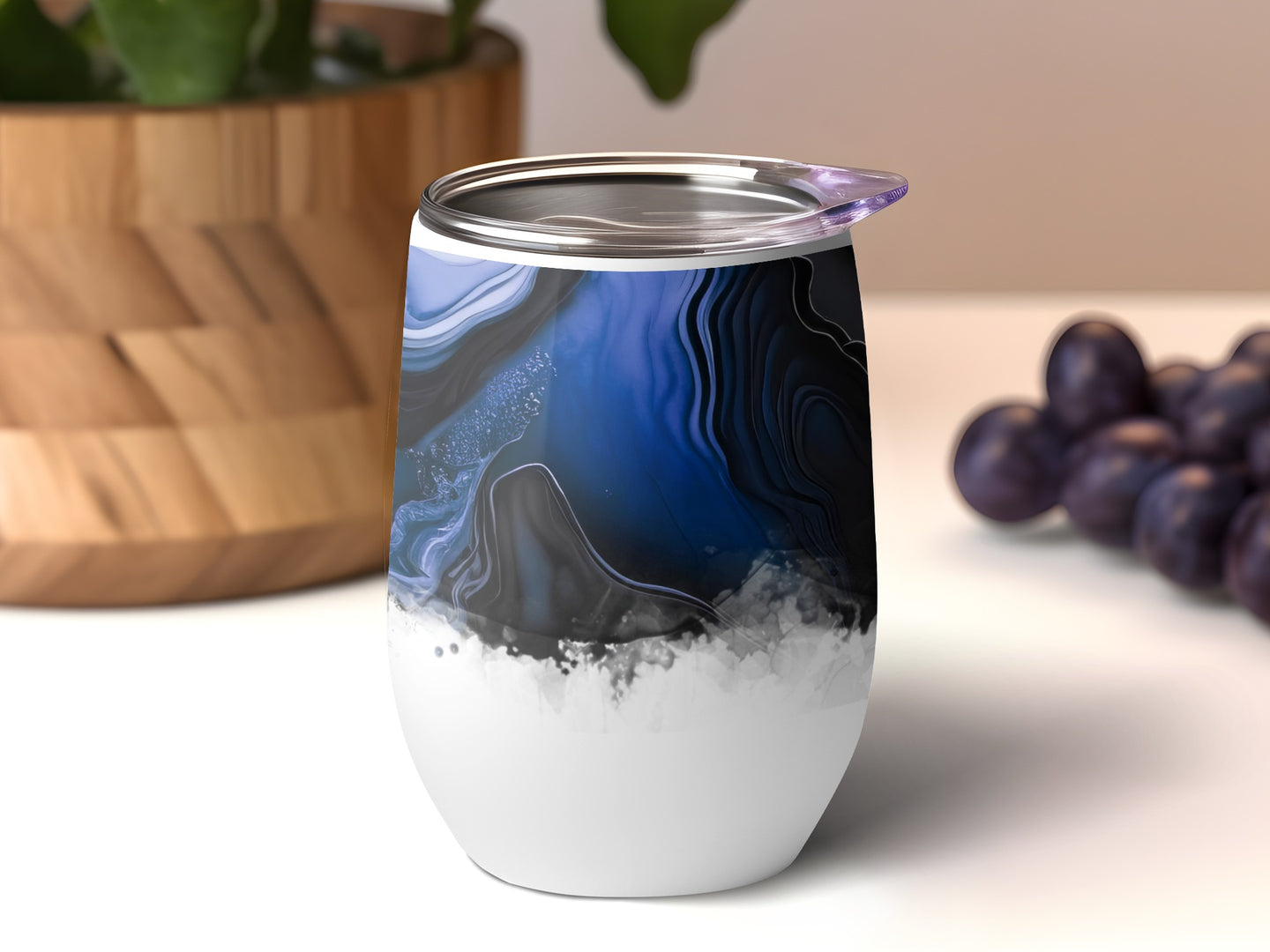 Tumbler with abstract blue and black marble pattern on white base.