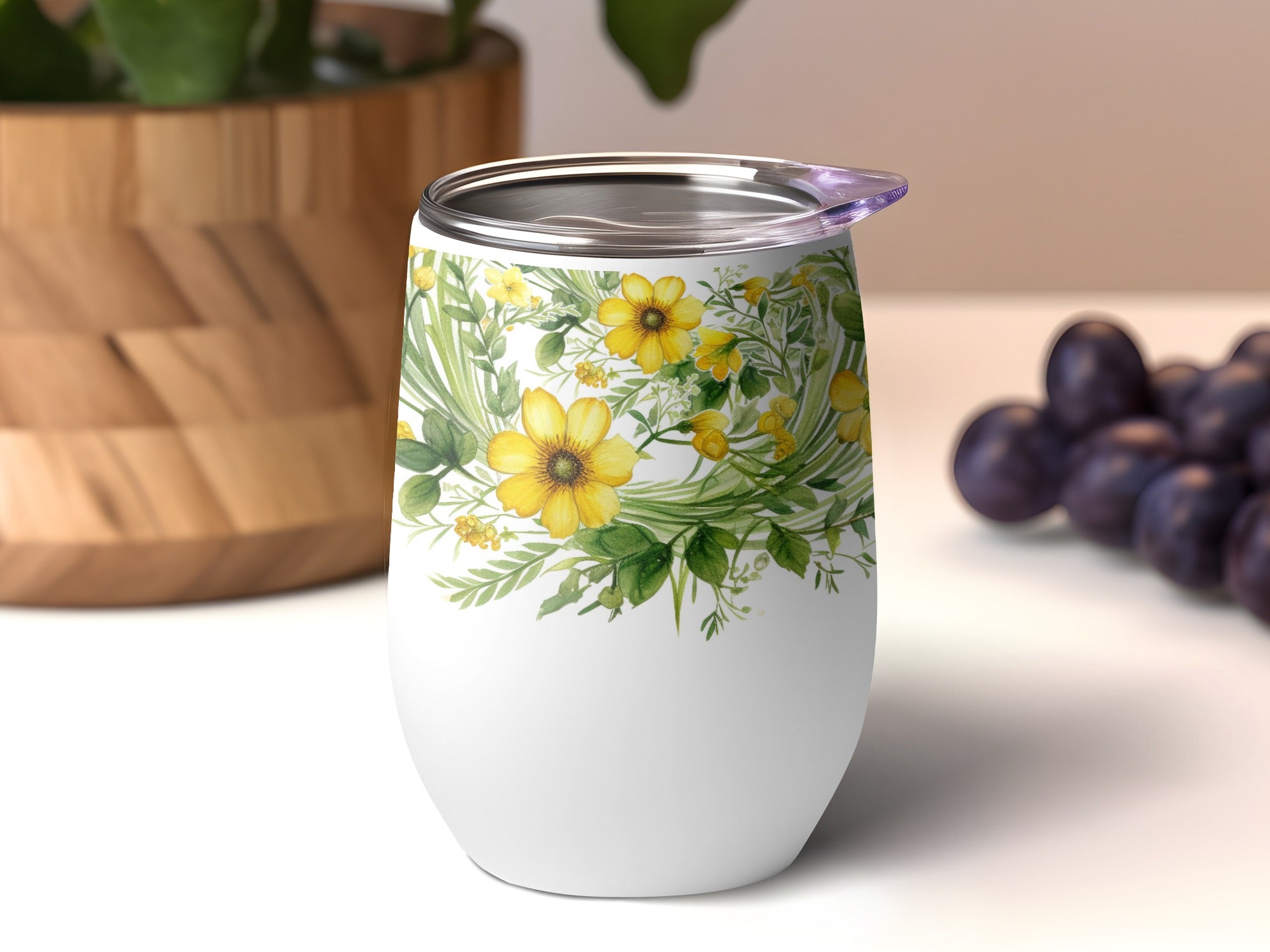 White tumbler with yellow floral design and a clear lid.