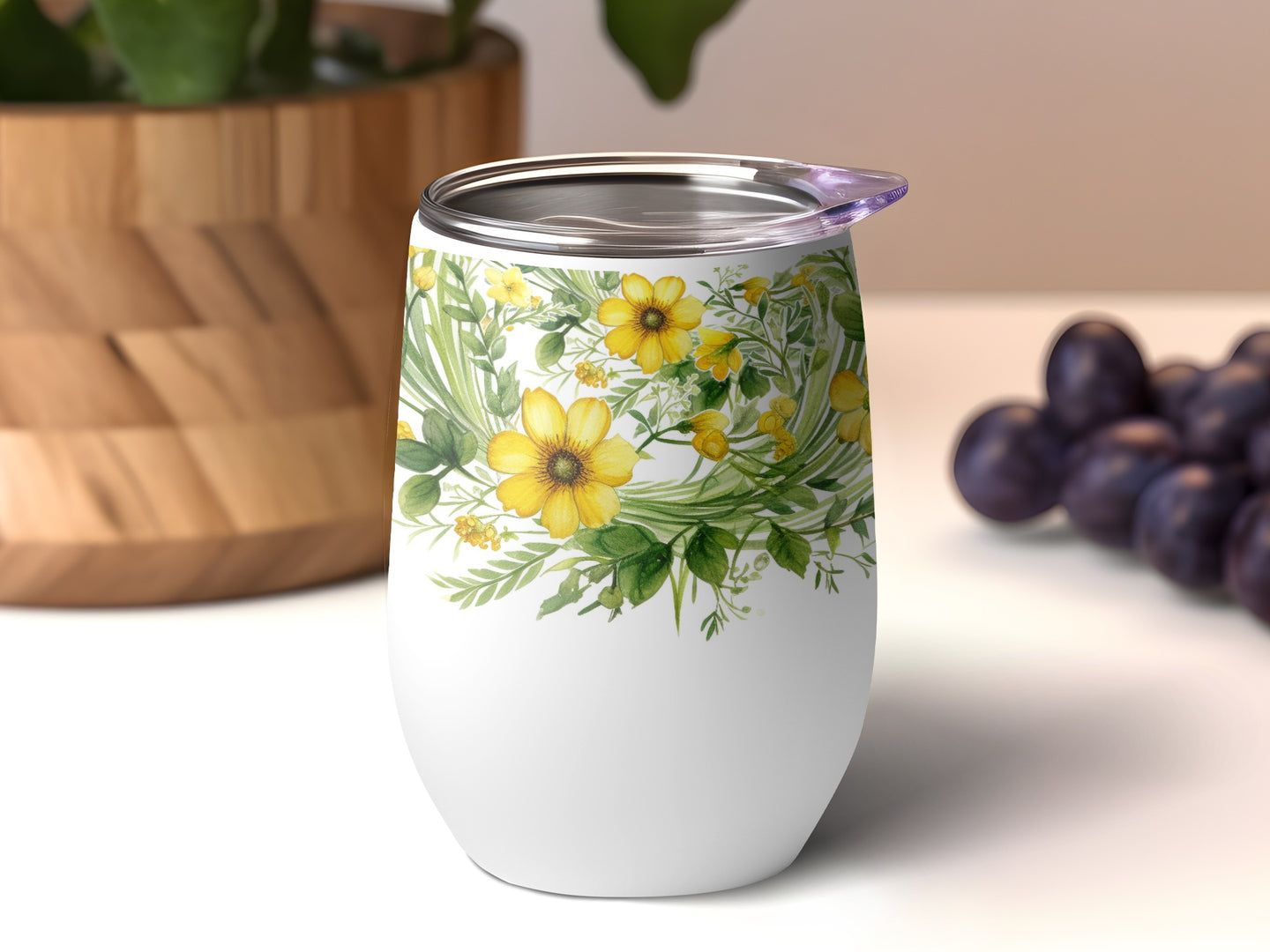 White tumbler with yellow floral design and a clear lid.