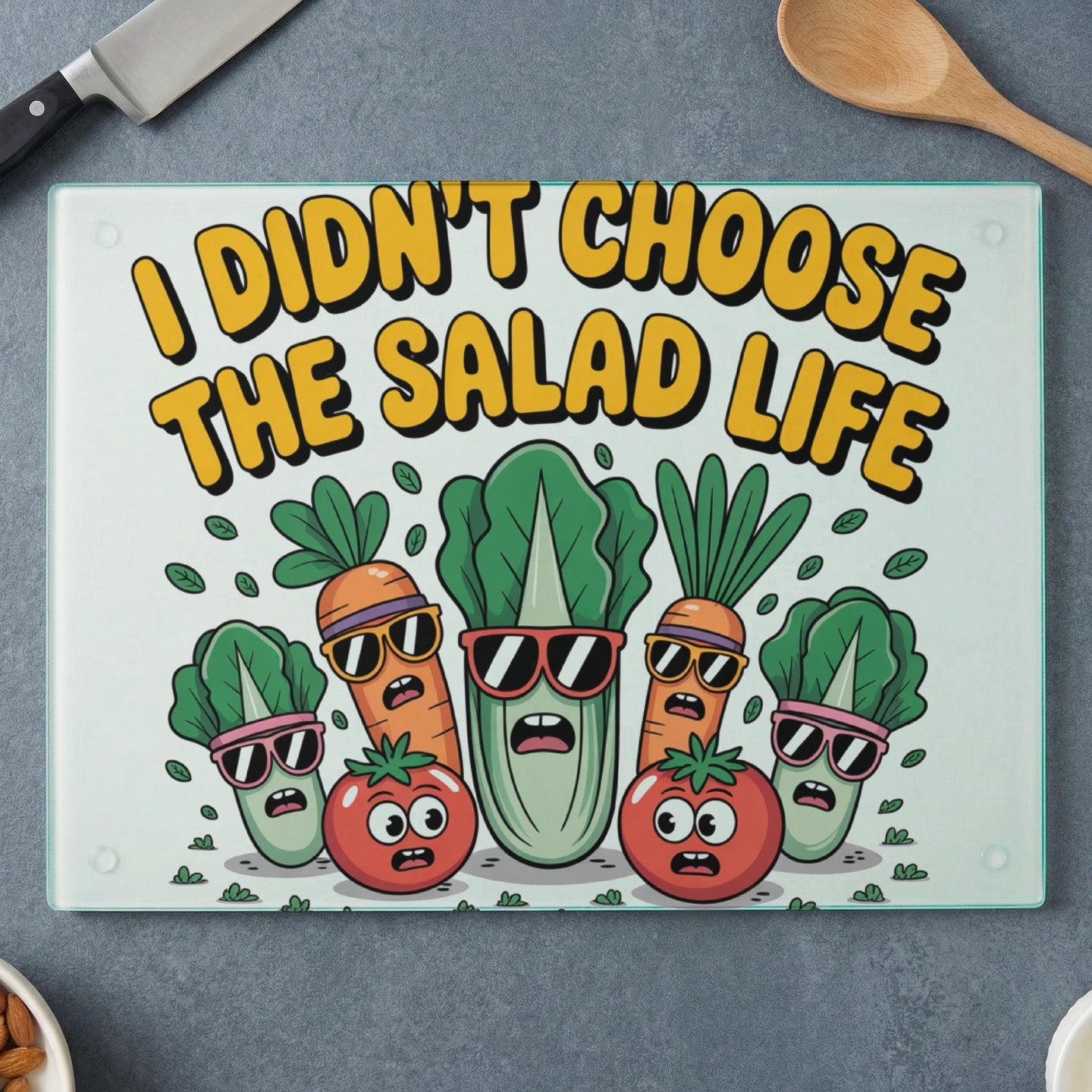 Cutting board with cartoon vegetables wearing sunglasses and "I didn't choose the salad life" text.