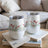 Two white tumblers with red poppies and green grass pattern.