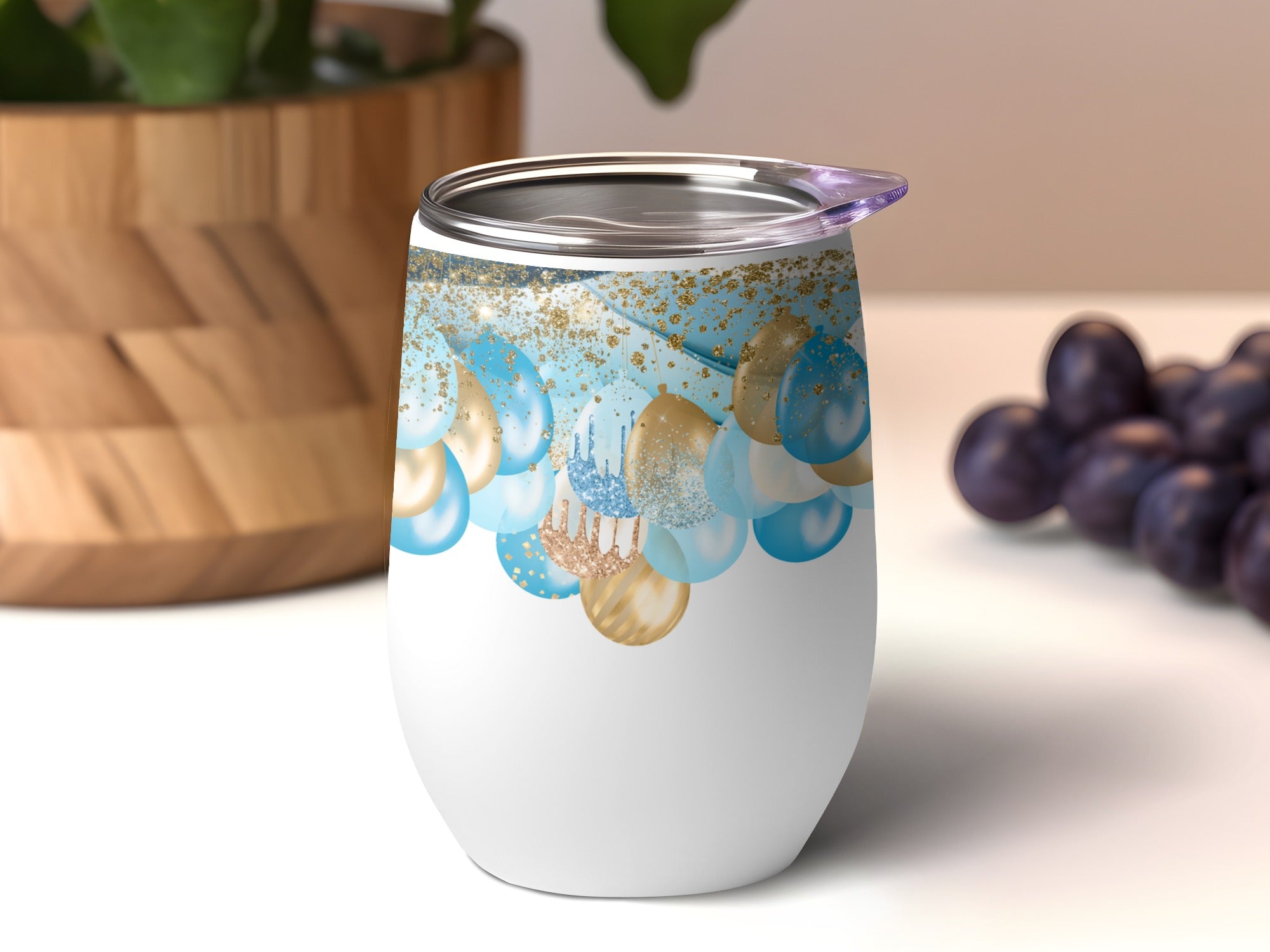 White tumbler with blue and gold balloons and confetti design.