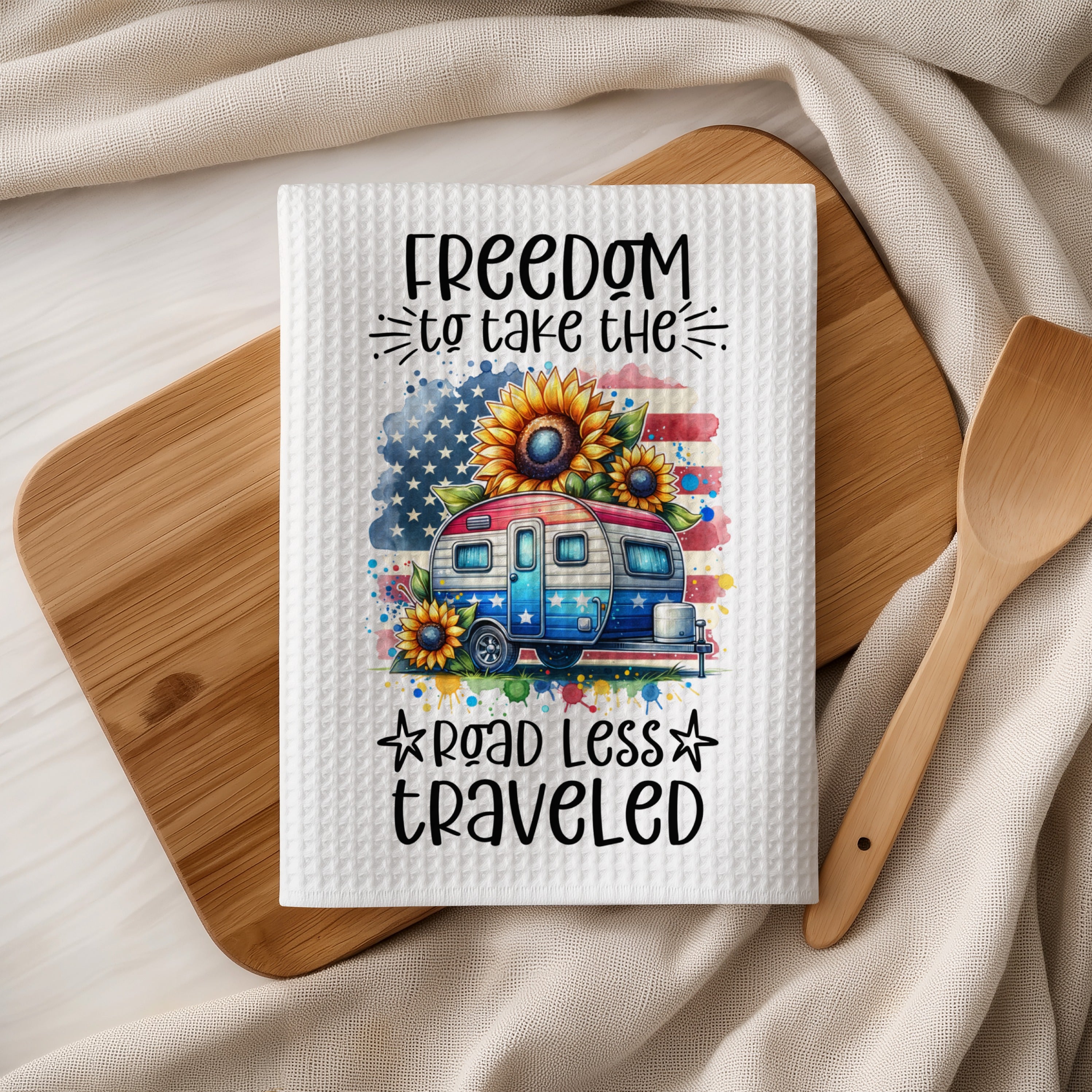 Waffle towel with camper, sunflowers, and US flag, reads "FREEDOM to take the ROAD LESS TRAVELED".