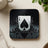 Ace of spades card design on a black liquid splash coaster.