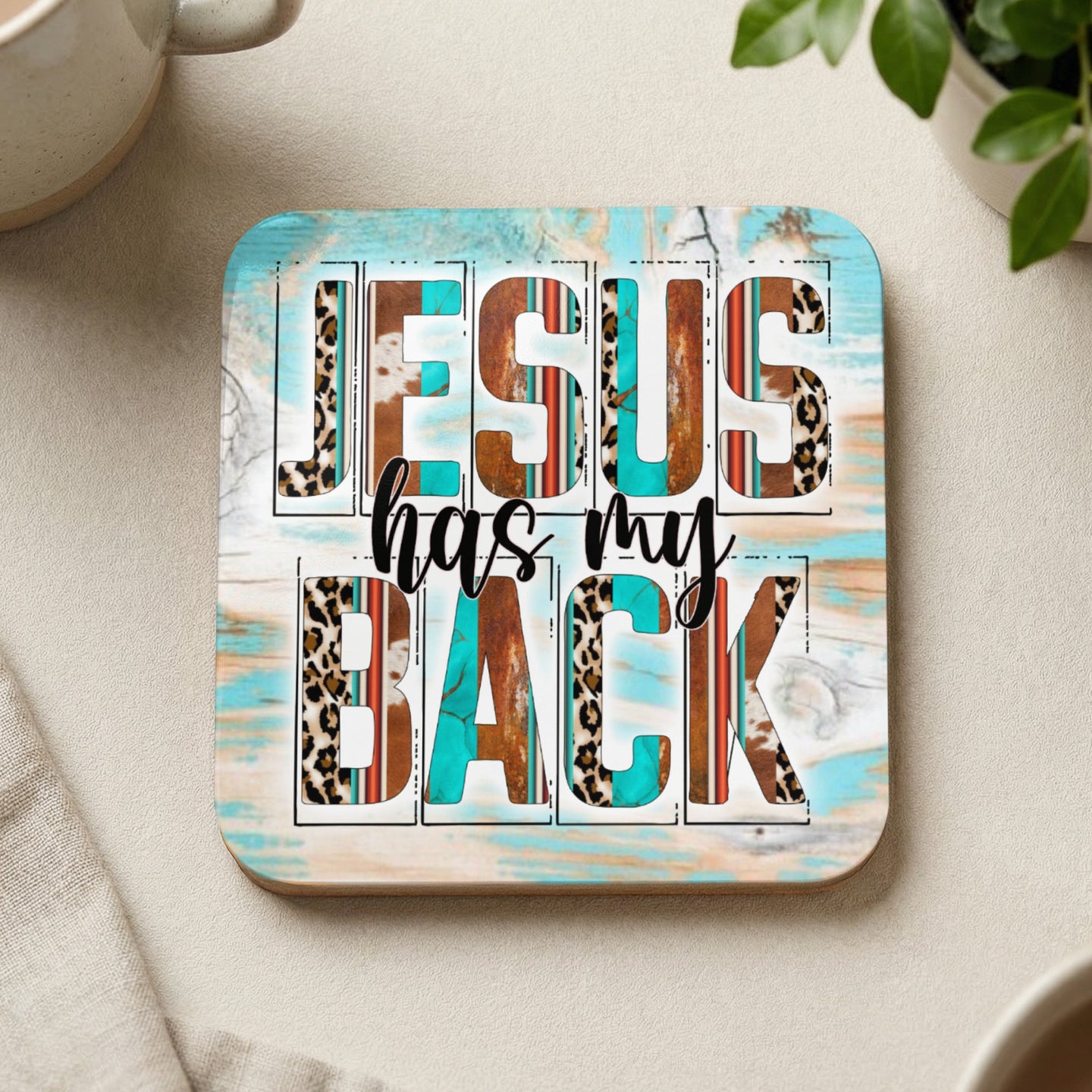 Coaster with "JESUS HAS MY BACK" text and wood, leopard, and turquoise patterns.