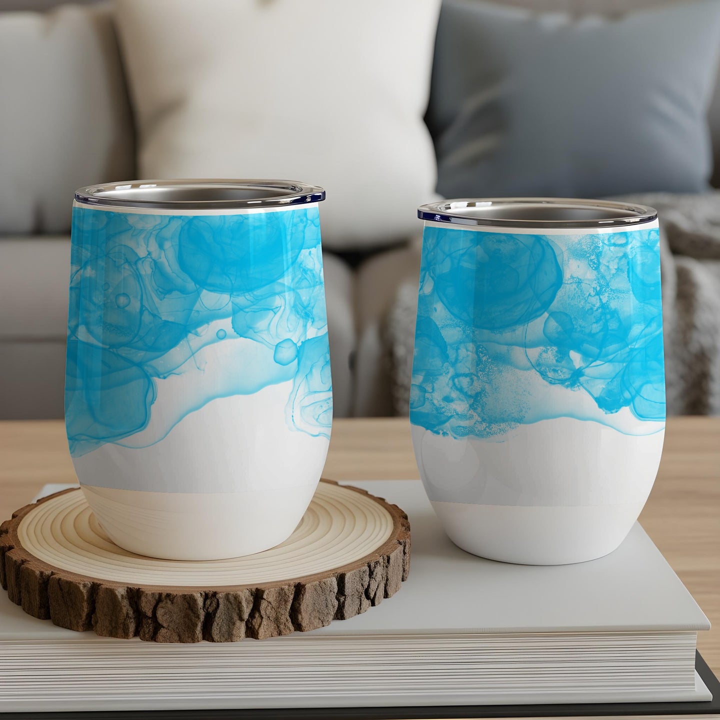 Two white stemless wine tumblers with blue abstract watercolor design.