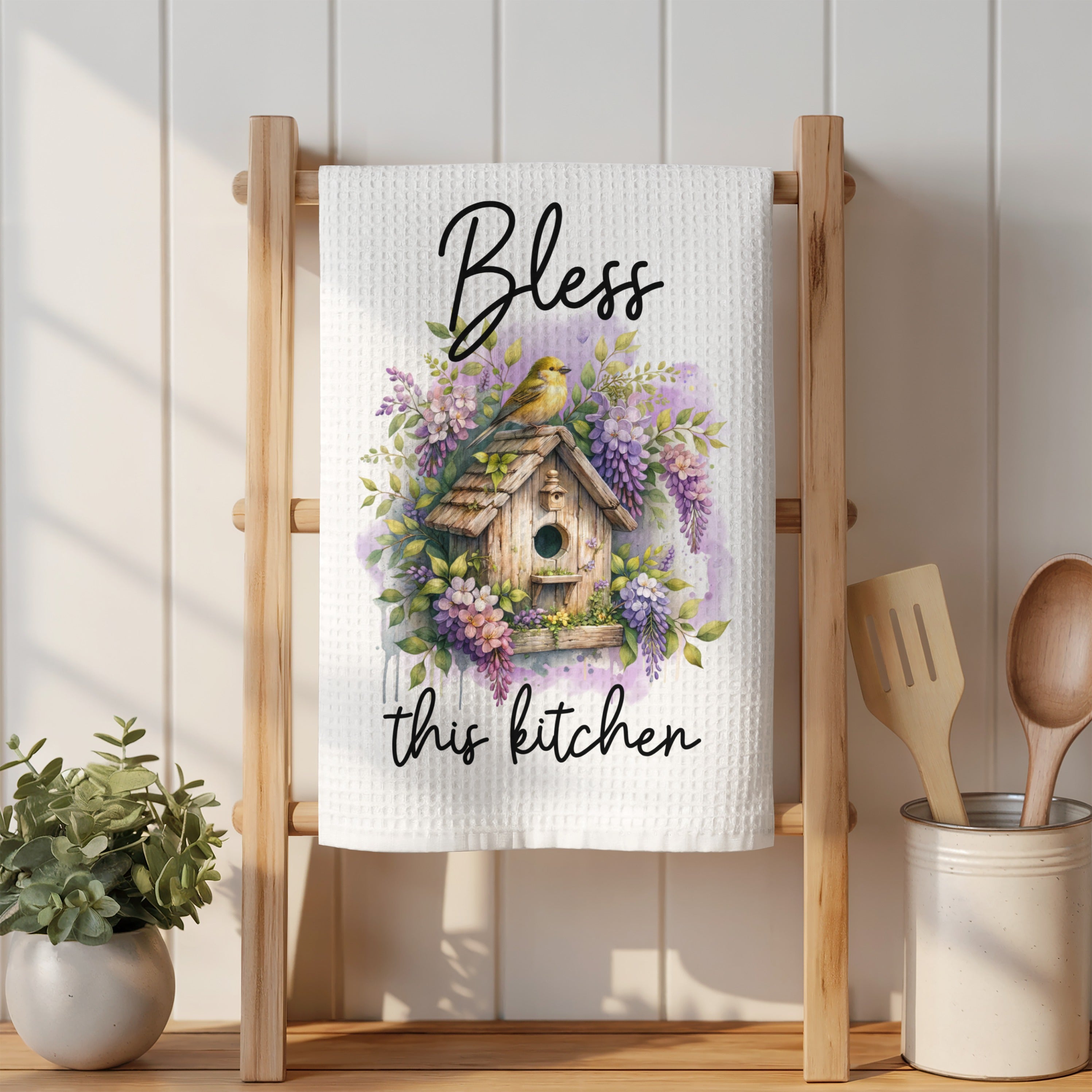 White kitchen towel with "Bless this kitchen" and birdhouse watercolor design.