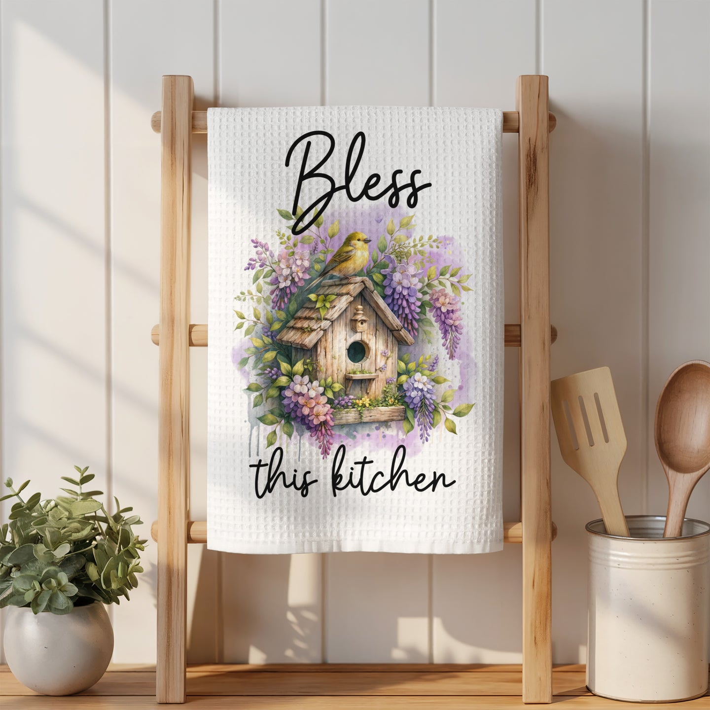 White kitchen towel with "Bless this kitchen" and birdhouse watercolor design.