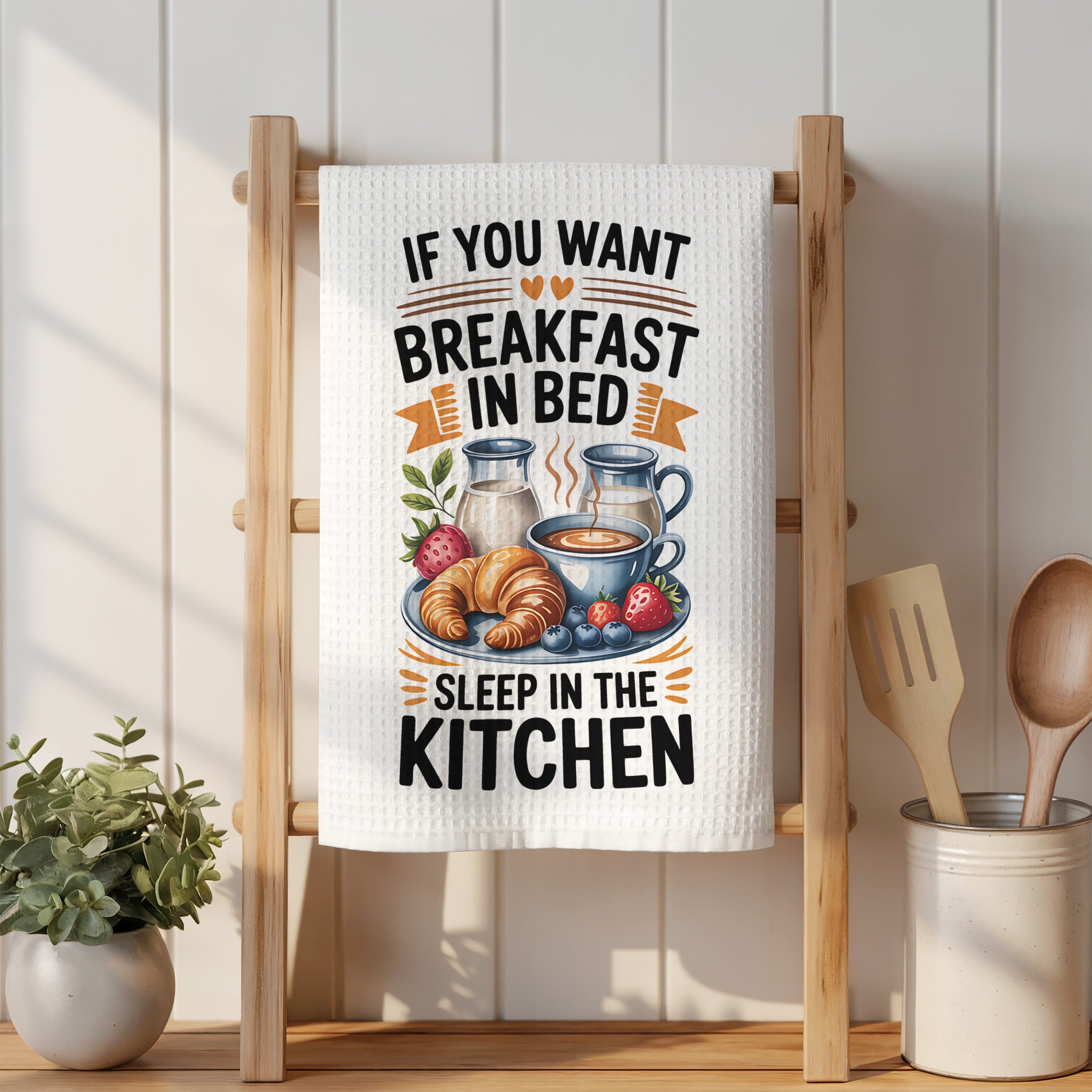 Kitchen towel with text "If you want breakfast in bed sleep in the kitchen" and breakfast illustration.
