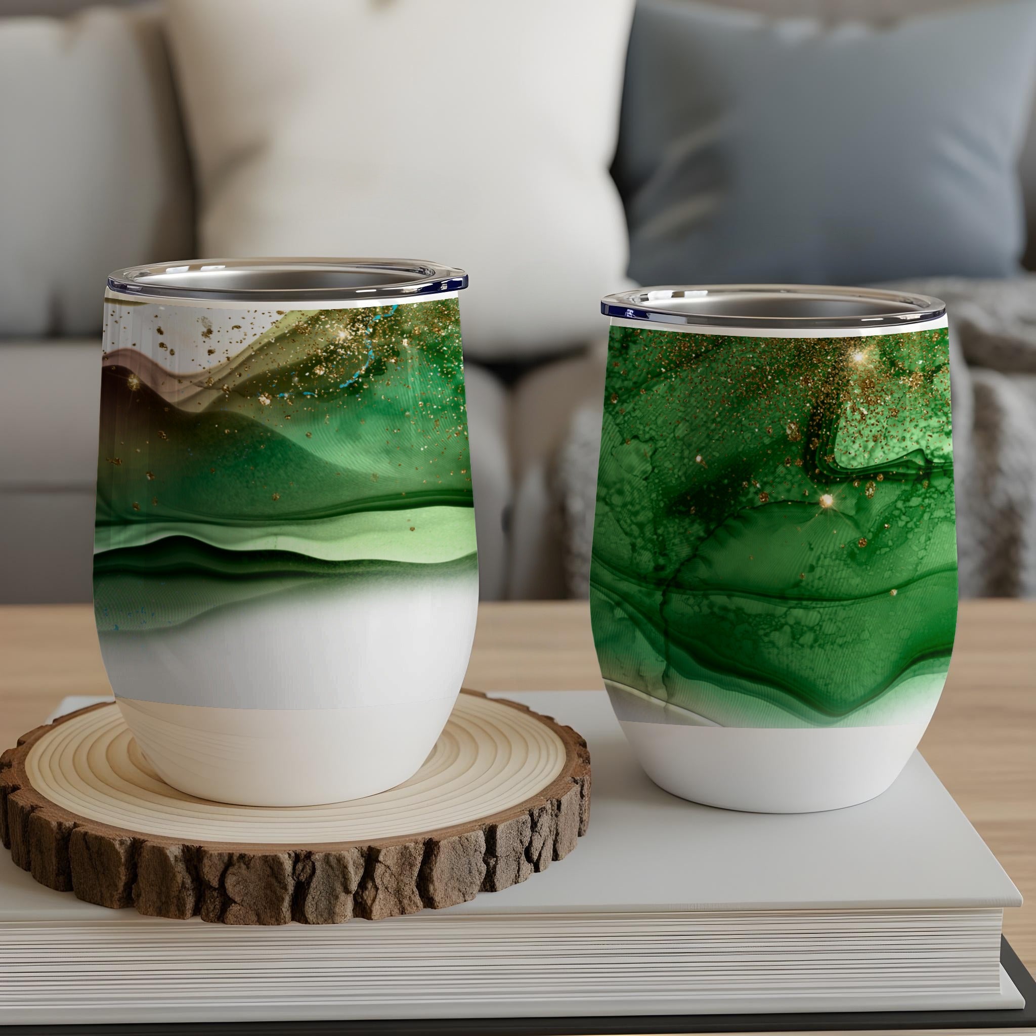 Two green marbled tumblers with gold glitter on a wooden coaster.