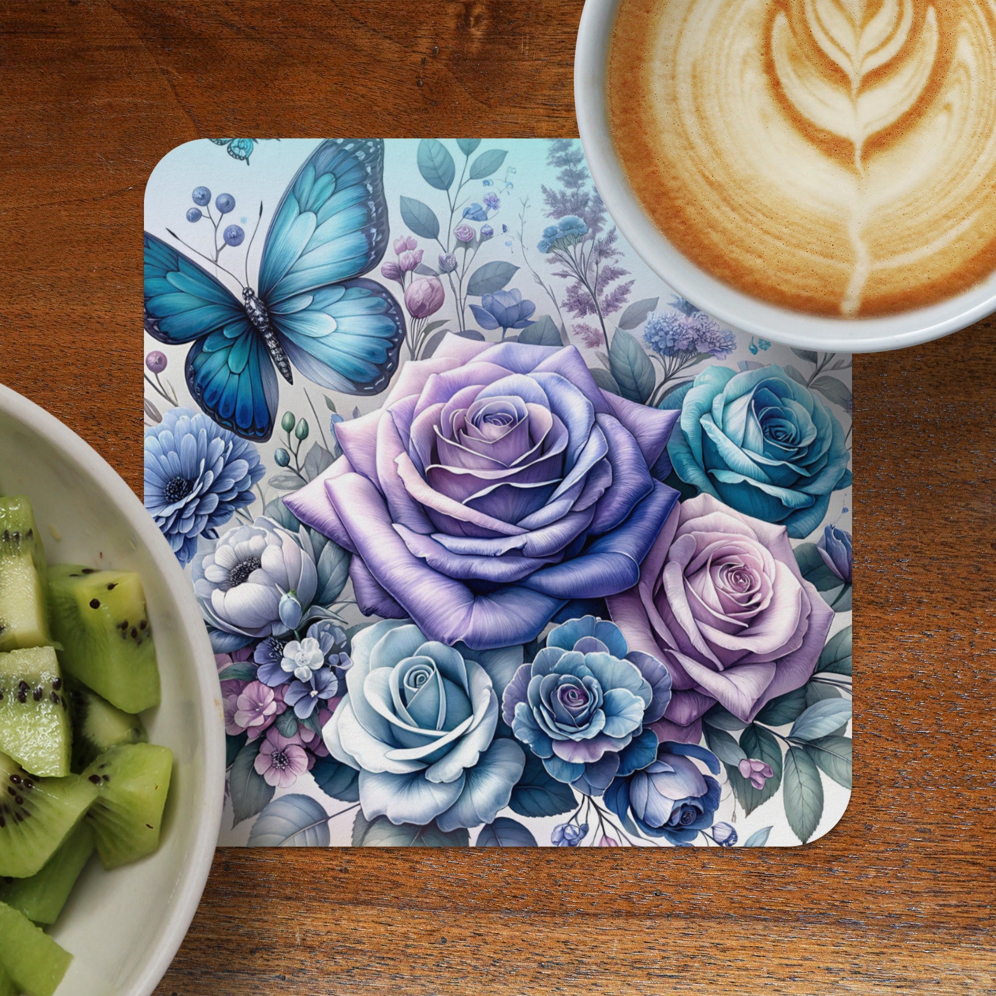 Blue butterfly and purple roses on a coaster with kiwi and coffee.