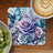 Blue butterfly and purple roses on a coaster with kiwi and coffee.