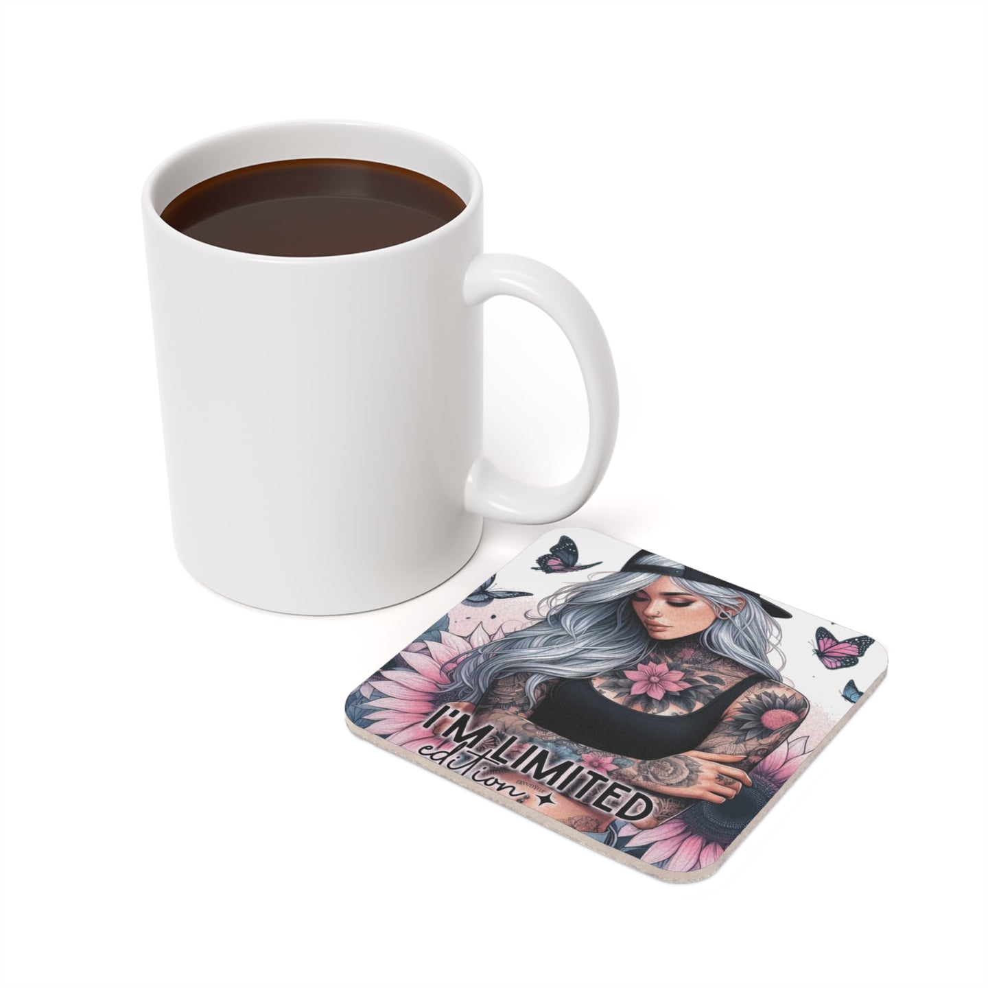 White mug with coffee next to a square coaster featuring tattooed woman and butterflies.